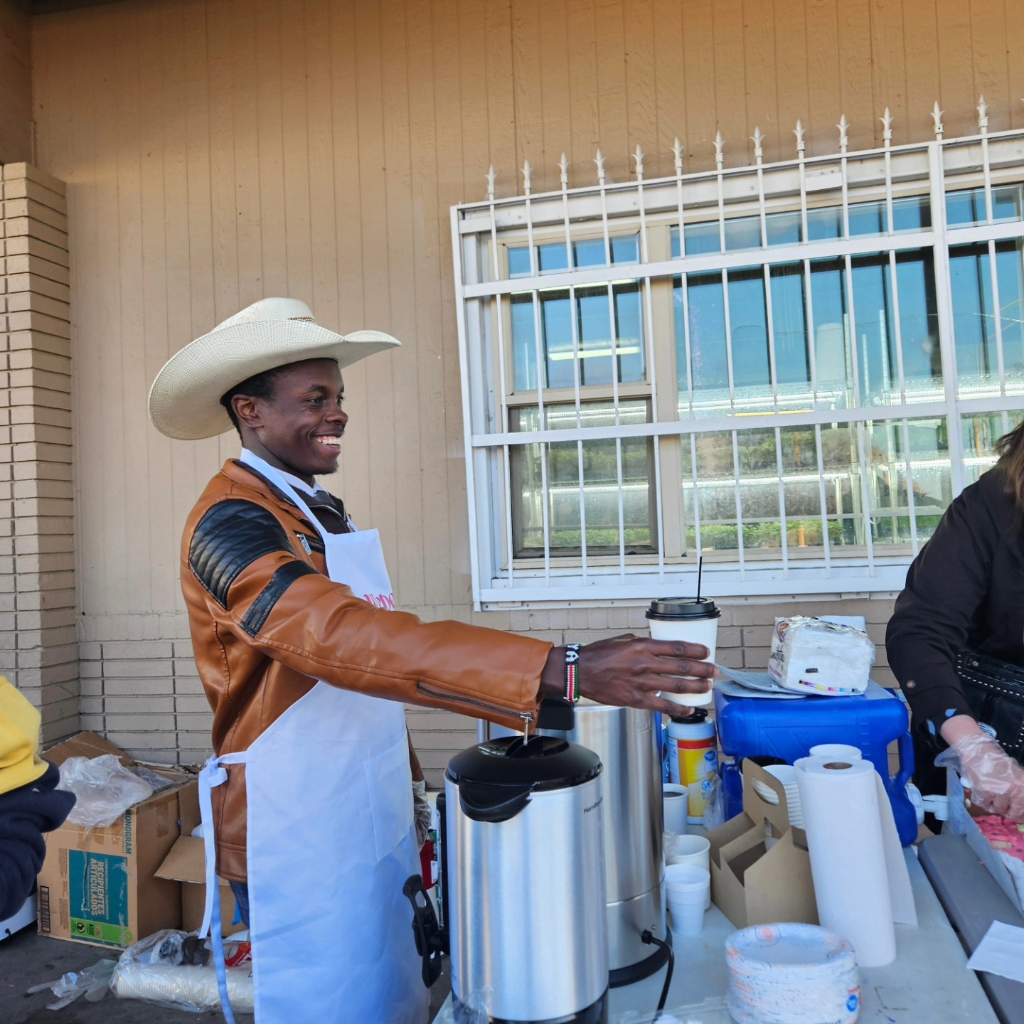 A volunteer serving coffee at a Weber Fridge community breakfast event